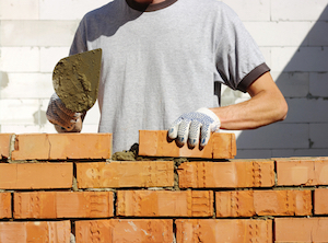 bricklayer laying bricks to make a wall